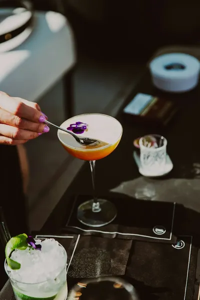 Bartender adding an edible flower garnish