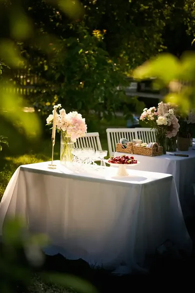 Sunlit garden table with flowers and cherries