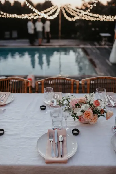 Wedding table with garden roses set beside a pool
